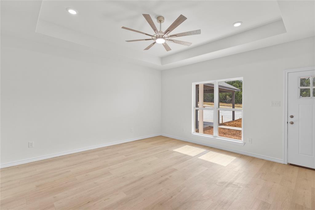 123 Cedar Shadow Lane Whitney, TX 76692 - Photo 6 of 27 an empty room with windows and fan