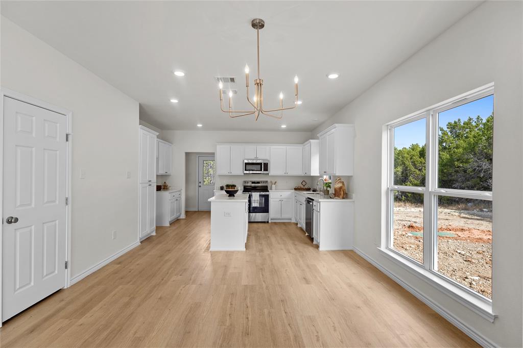 123 Cedar Shadow Lane Whitney, TX 76692 - Photo 7 of 27 a view of a big room with wooden floor windows and a kitchen