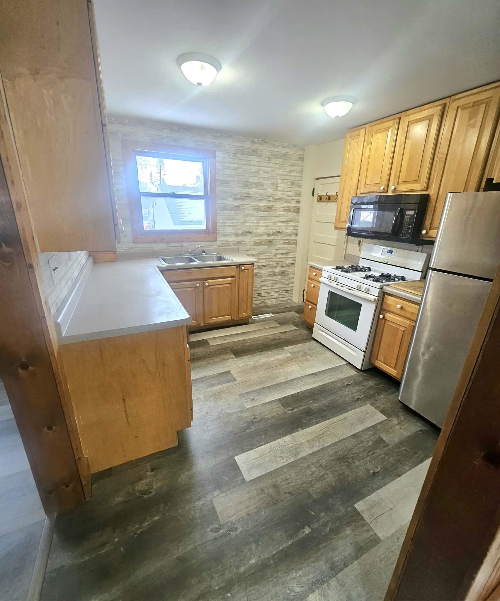 110 South 8th Street Beloit, WI 53511 - Photo 3 of 19 a kitchen with stainless steel appliances wooden cabinets and a stove top oven