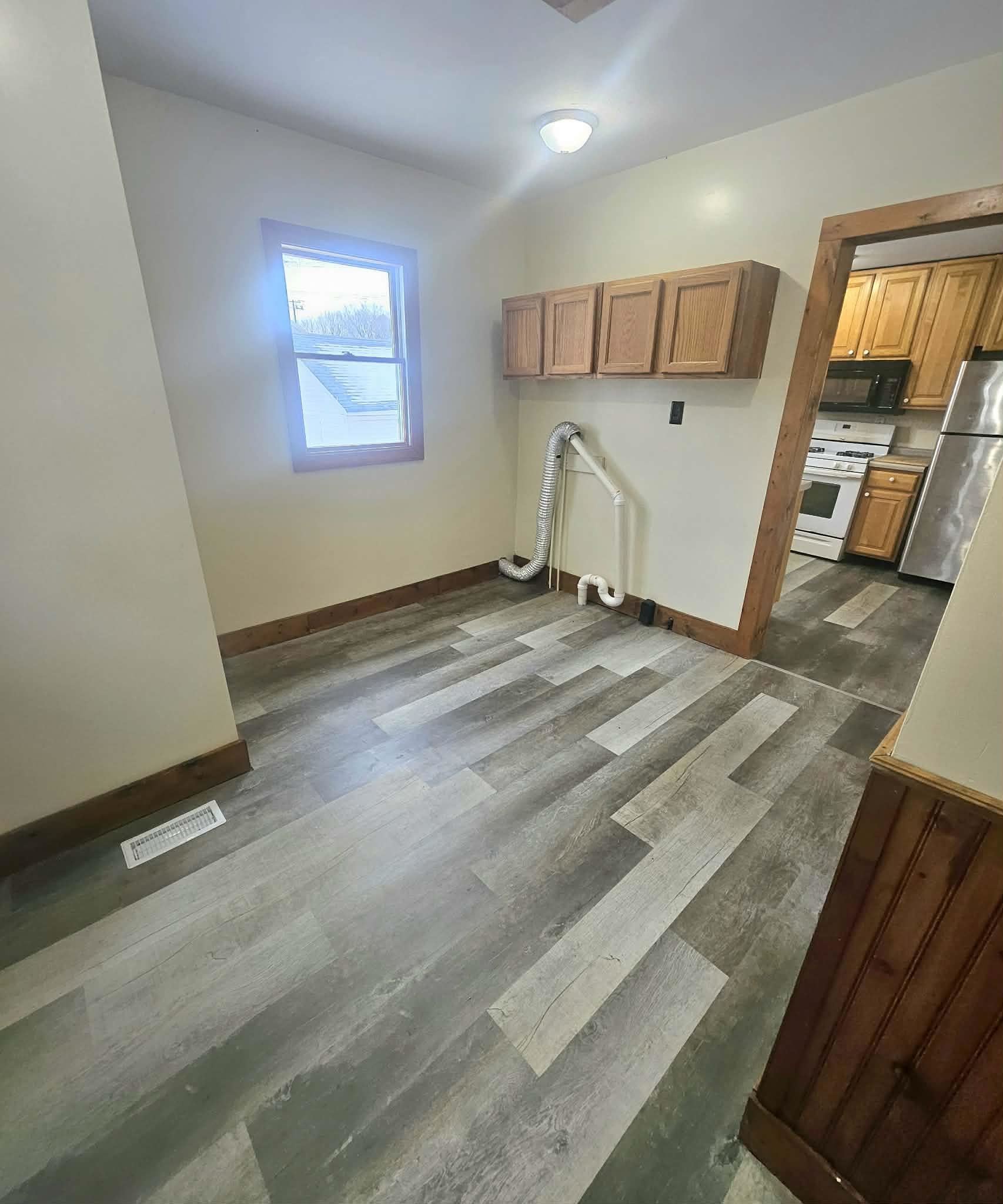 110 South 8th Street Beloit, WI 53511 - Photo 10 of 19 a view of a hallway to a bedroom with wooden floor and windows