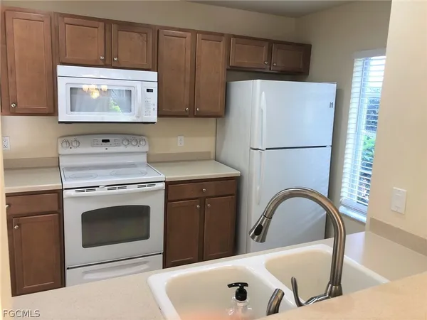 a kitchen with granite countertop a white stove top oven and refrigerator