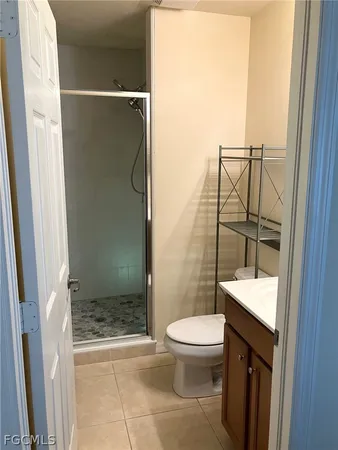 a bathroom with a granite countertop toilet and a shower