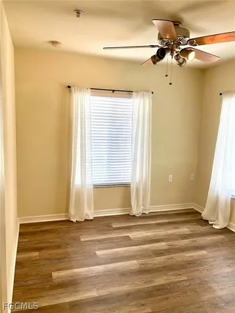 a view of a room with a ceiling fan and window