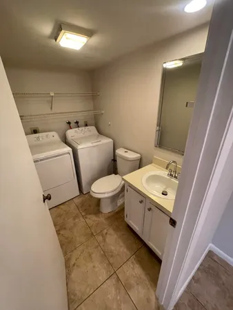 a bathroom with a toilet sink and mirror