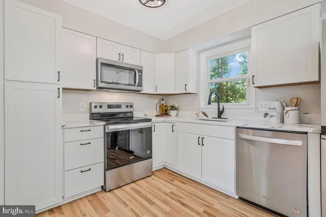 a kitchen with white cabinets and stainless steel appliances