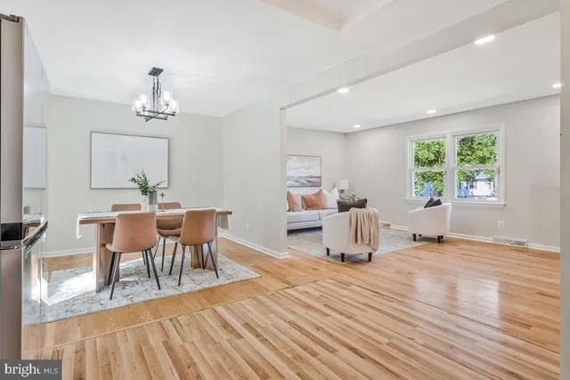 a dining room with wooden floor a chandelier a glass table and chairs