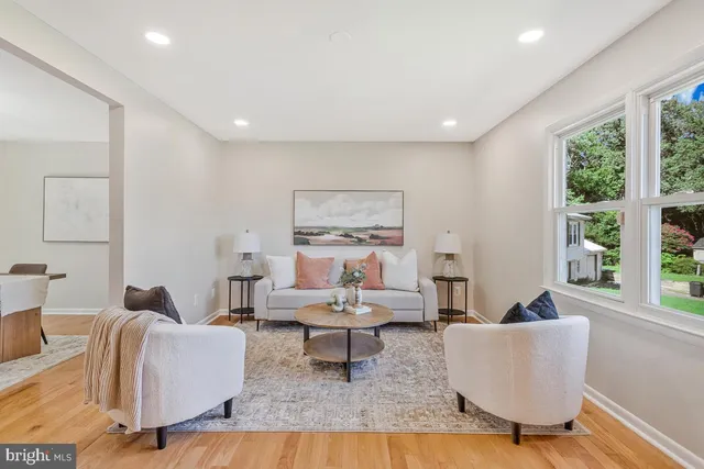 a living room with furniture a window and a potted plant