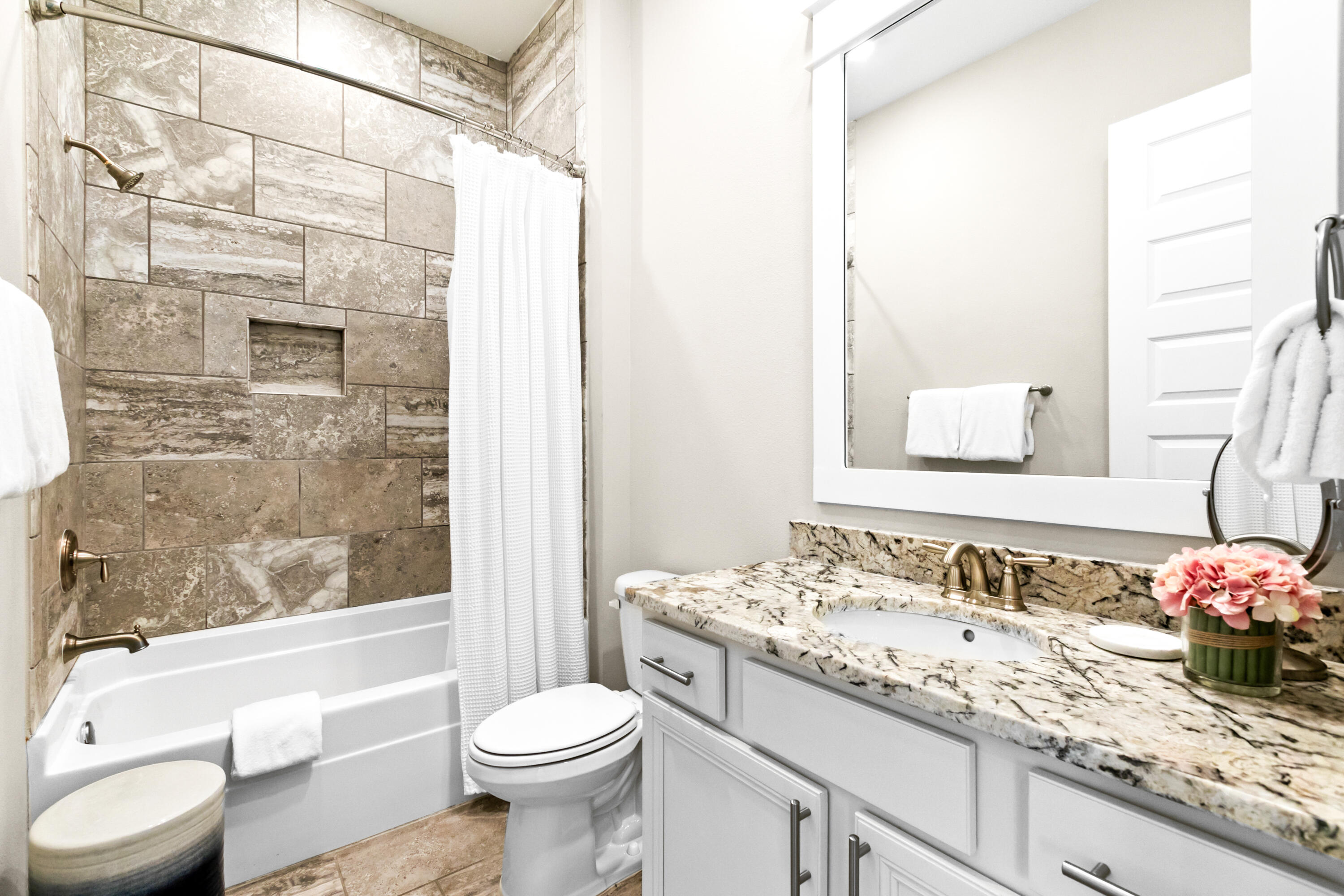 111 East Milestone Drive, Unit C Inlet Beach, FL 32461 - Photo 24 of 37 a bathroom with a granite countertop sink toilet mirror and bathtub