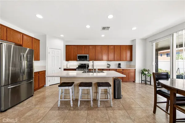 a kitchen with stainless steel appliances granite countertop a sink dishwasher stove top oven refrigerator and cabinets