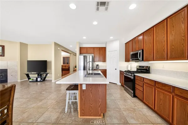 a large kitchen with stainless steel appliances kitchen island granite countertop a table and chairs in it