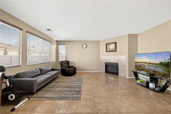 a living room with furniture a flat screen tv and a window