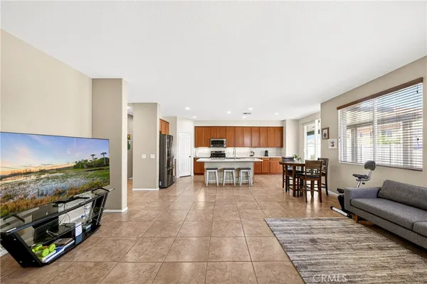 a living room with furniture and a dining table with wooden floor