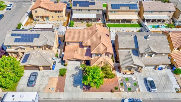 an aerial view of residential houses with outdoor space and parking