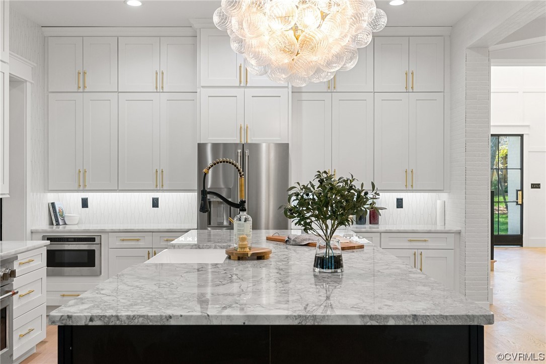 8576 Barrique Road New Kent, VA 23124 - Photo 6 of 50 a kitchen with kitchen island granite countertop a sink a stove and a wooden floor