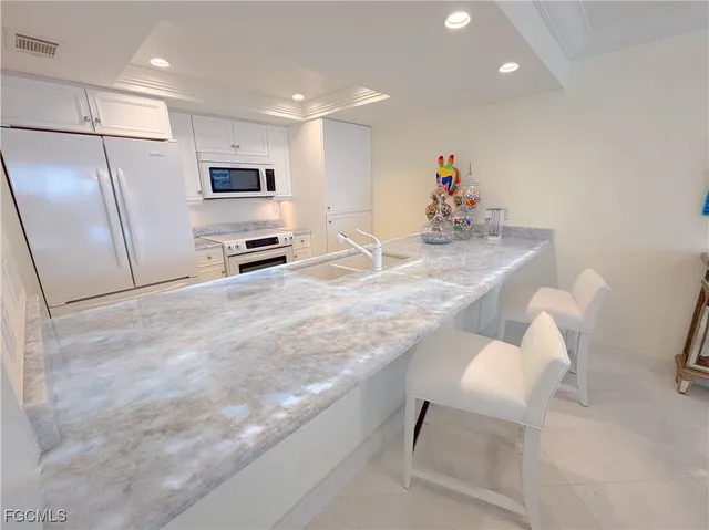 a kitchen with stainless steel appliances granite countertop a sink refrigerator and microwave