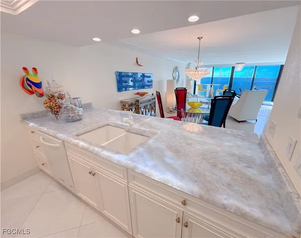 a kitchen with stainless steel appliances kitchen island granite countertop a sink and white cabinets