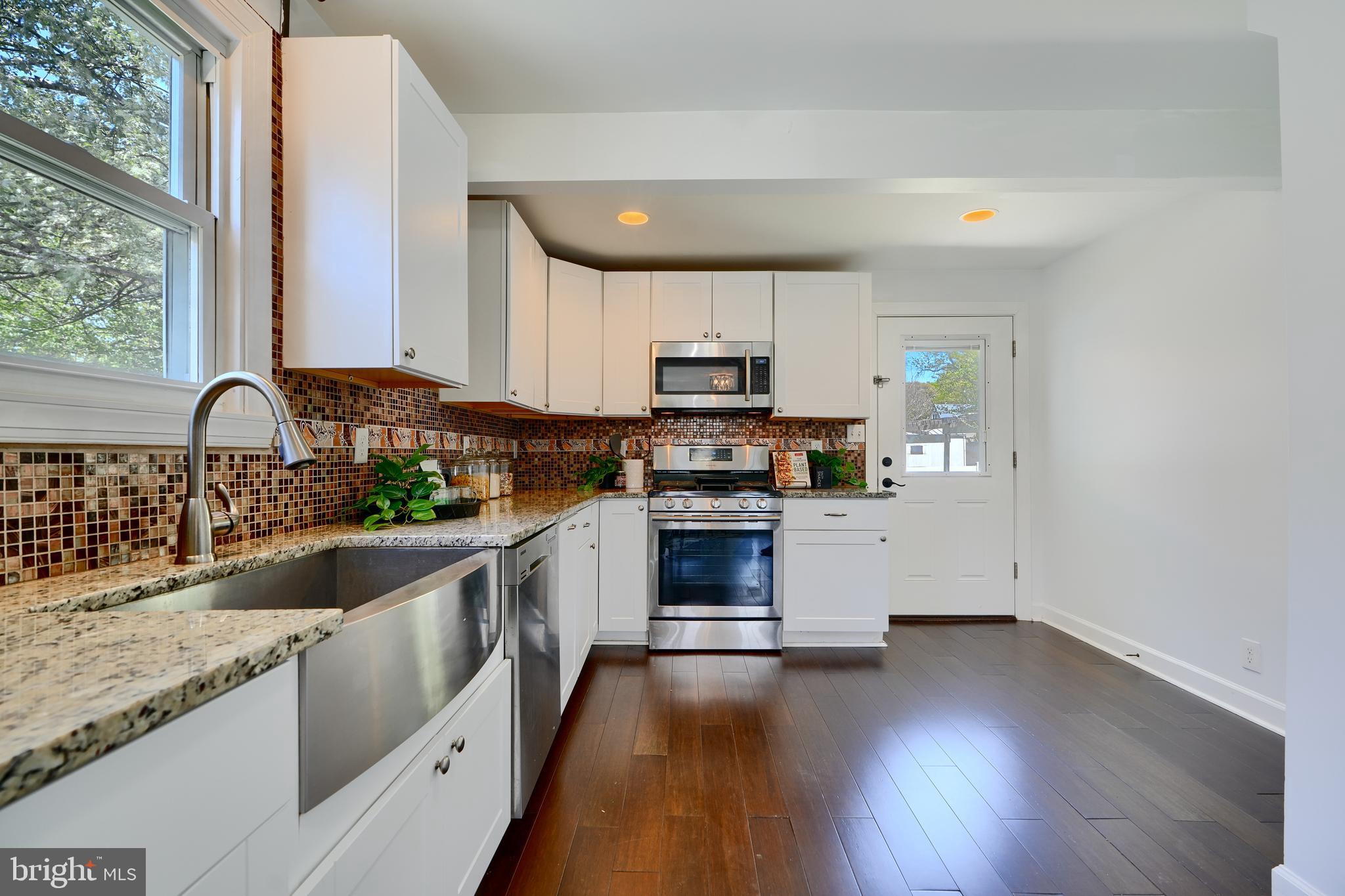 294 Stillwater Road Baltimore, MD 21221 - Photo 13 of 40 a kitchen with granite countertop a stove a sink and a refrigerator