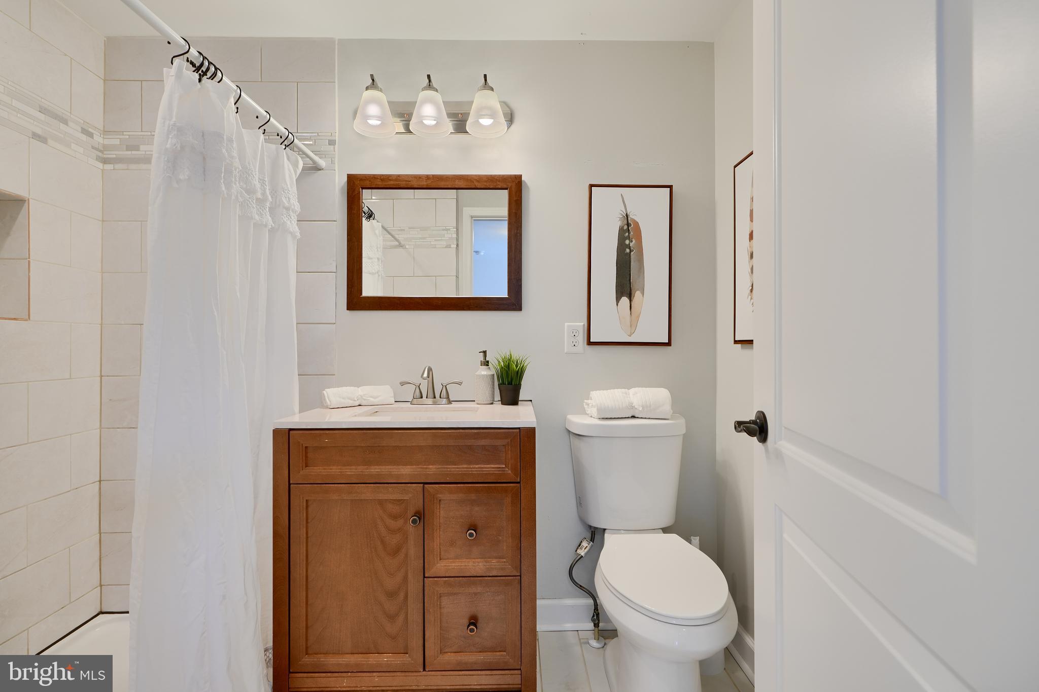 294 Stillwater Road Baltimore, MD 21221 - Photo 18 of 40 a bathroom with a toilet a sink and mirror