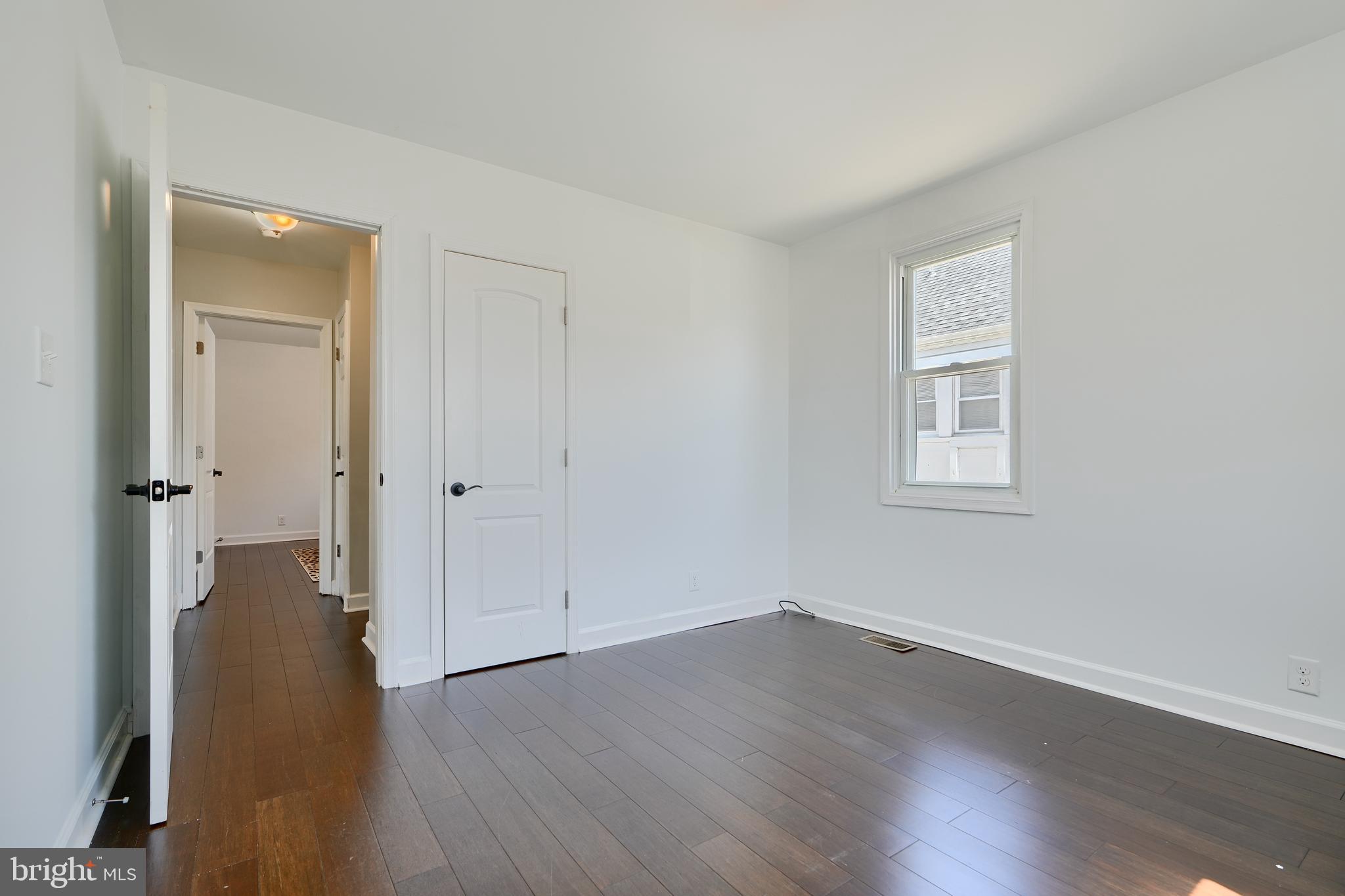 294 Stillwater Road Baltimore, MD 21221 - Photo 21 of 40 an empty room with wooden floor and a window