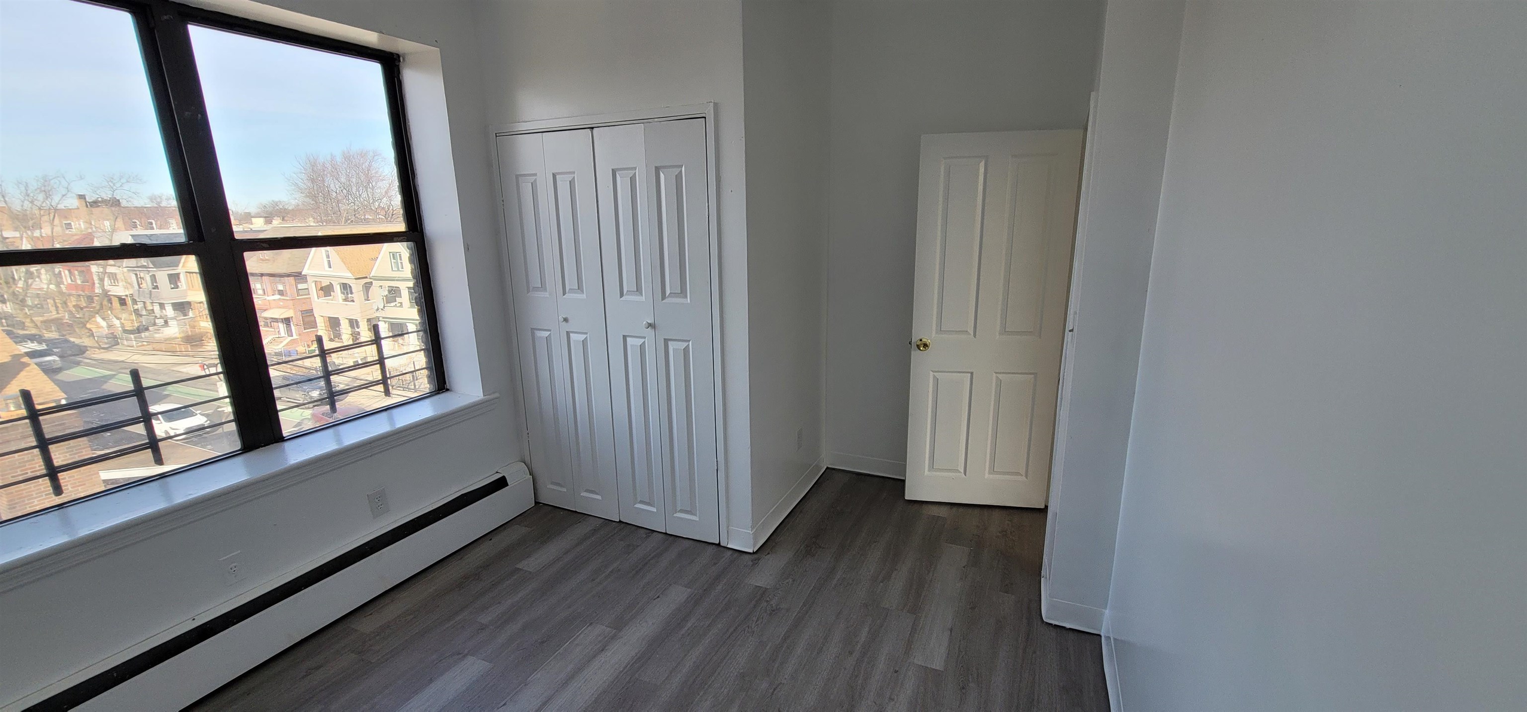 99 Rutgers Avenue, Unit 4C Jersey City, NJ 07305 - Photo 6 of 13 an empty room with wooden floor and windows