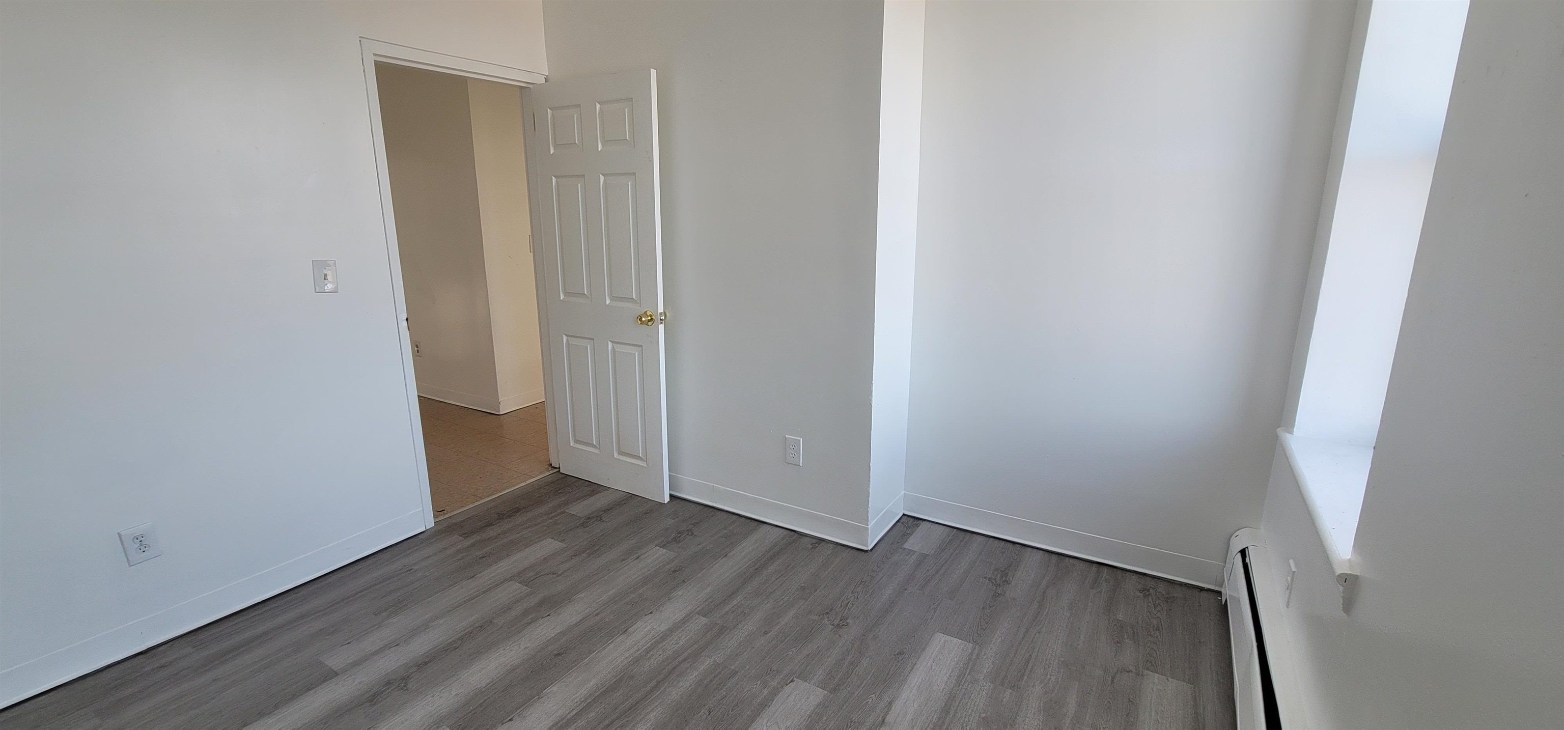 99 Rutgers Avenue, Unit 4C Jersey City, NJ 07305 - Photo 7 of 13 a view of an empty room with wooden floor