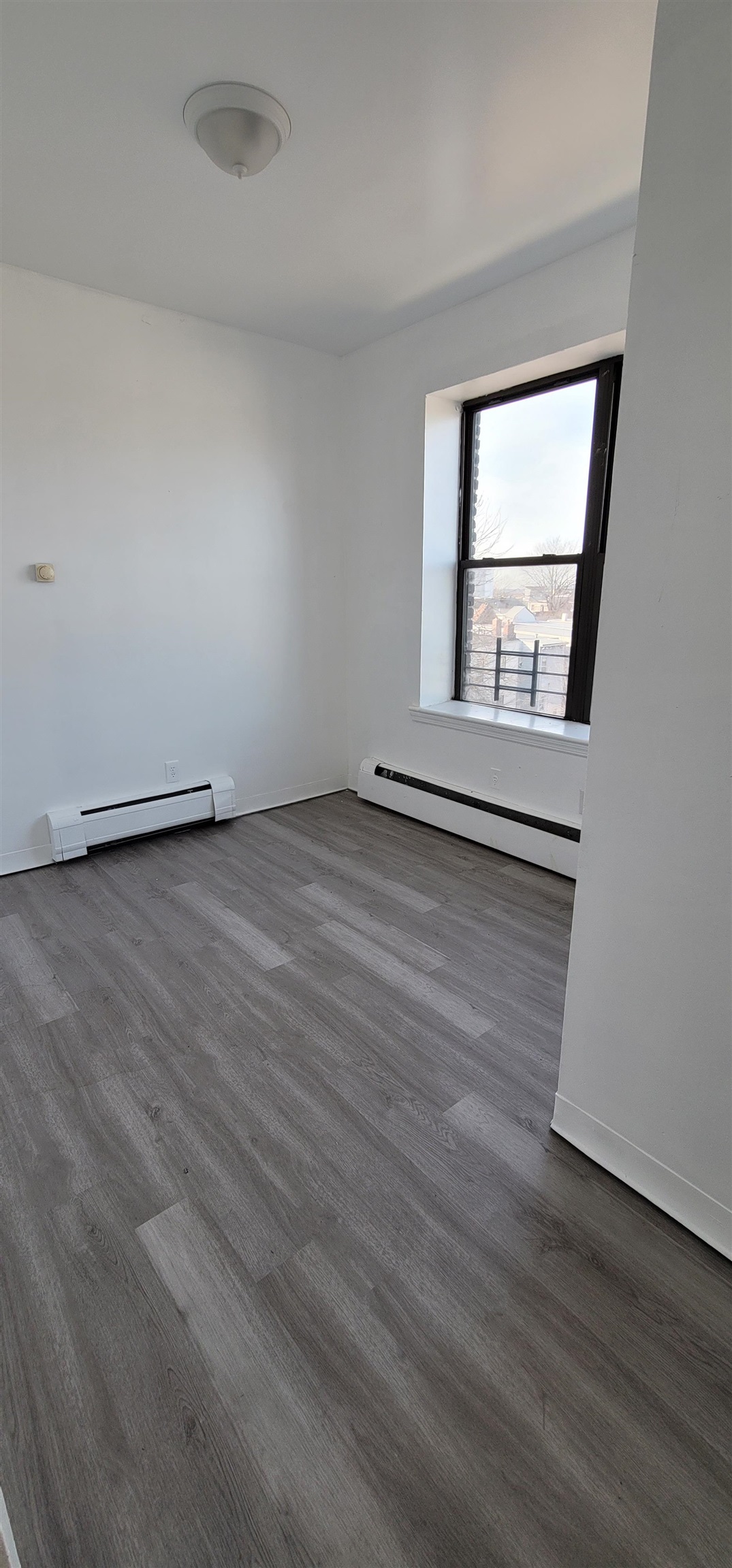 99 Rutgers Avenue, Unit 4C Jersey City, NJ 07305 - Photo 9 of 13 an empty room with wooden floor and windows