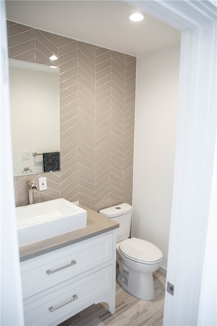 5908 Atlantic Avenue, Unit D Long Beach, CA 90805 - Photo 2 of 36 a bathroom with a granite countertop toilet a sink and a mirror