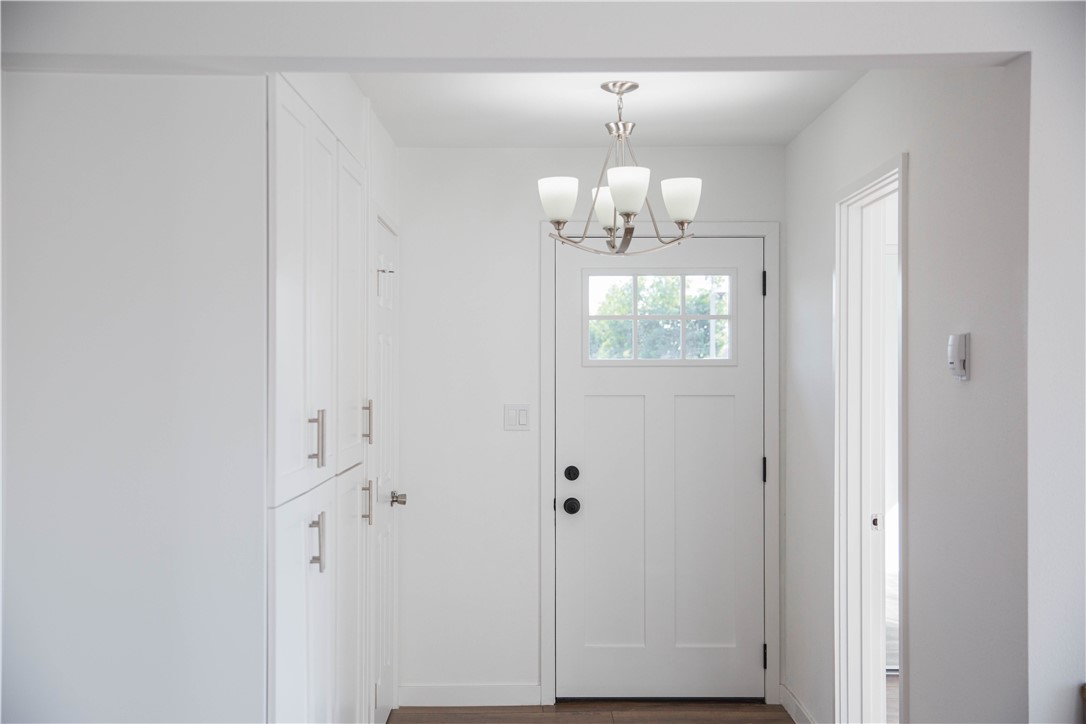 5908 Atlantic Avenue, Unit D Long Beach, CA 90805 - Photo 6 of 36 a view of a hallway with wooden floor and chandelier