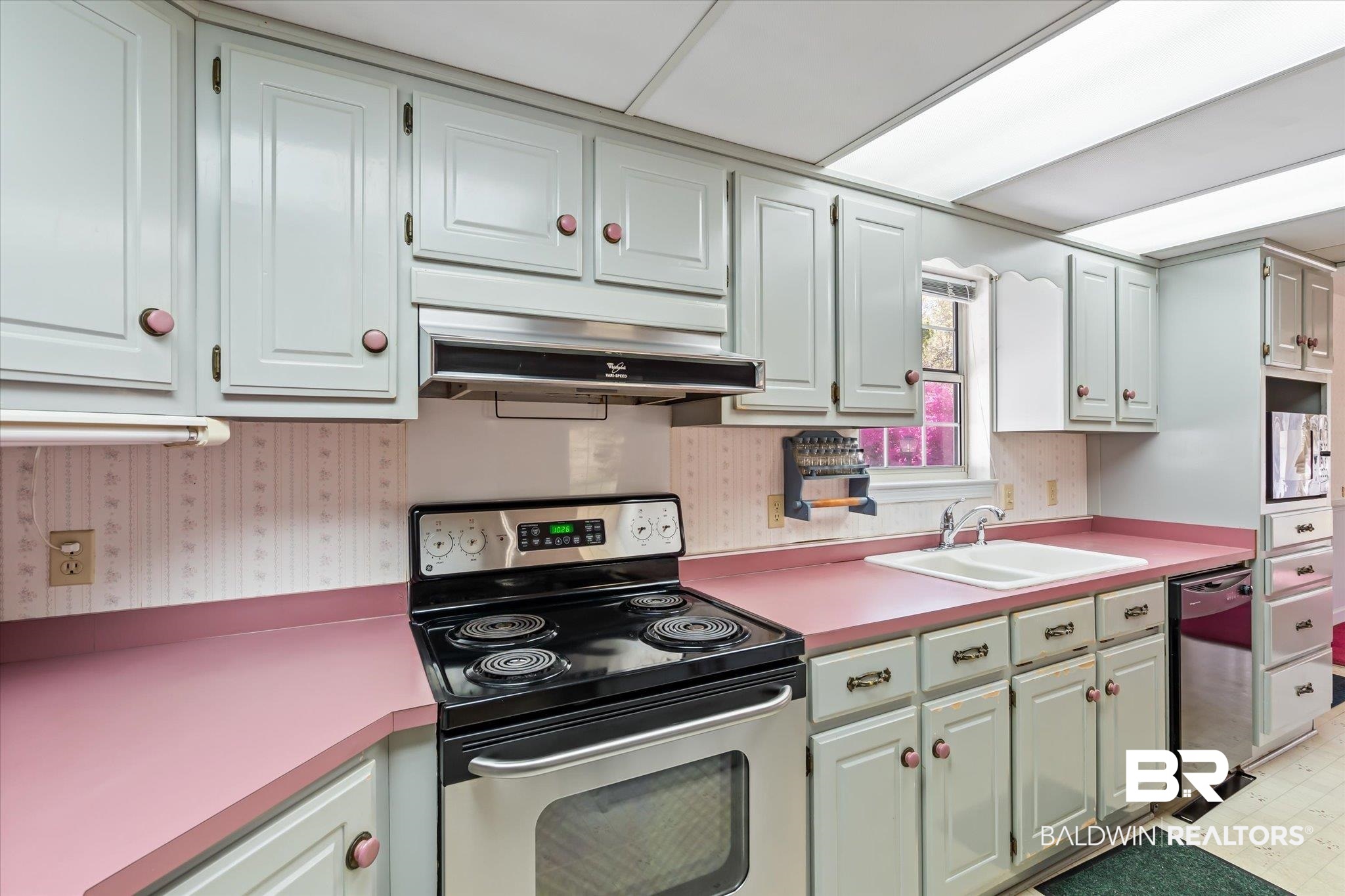 6030 Lott Road Eight Mile, AL 36613 - Photo 7 of 21 Kitchen featuring light countertops, under cabinet range hood, electric stove, a sink, and dishwashing machine
