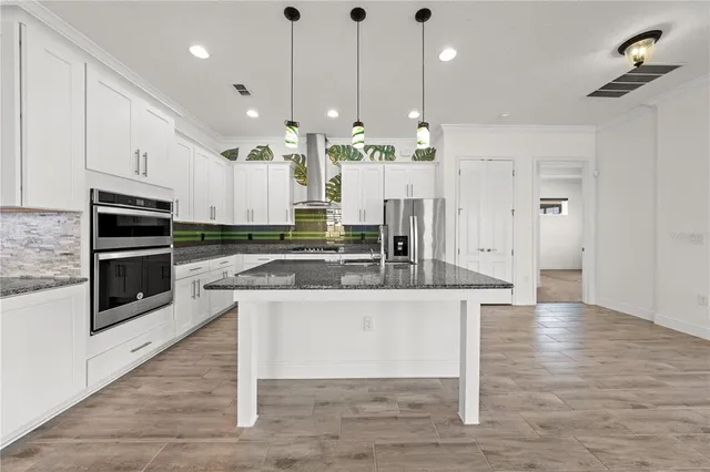 a view of an empty room with a large window with ceiling fan