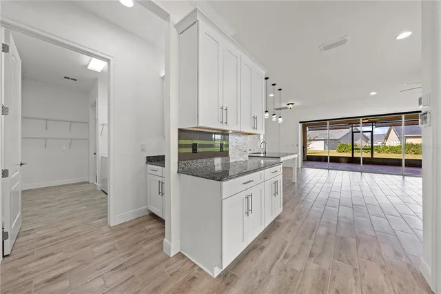 a kitchen with stainless steel appliances granite countertop a sink a stove and a wooden floors