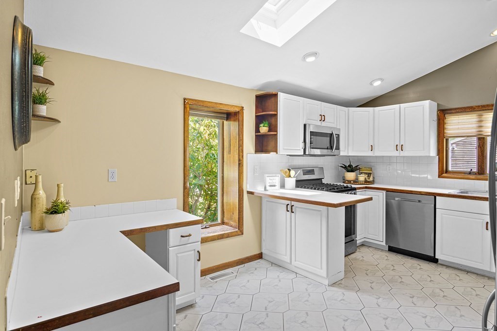118 Beach Road Salisbury, MA 01952 - Photo 10 of 29 a kitchen with stainless steel appliances granite countertop a sink and a refrigerator