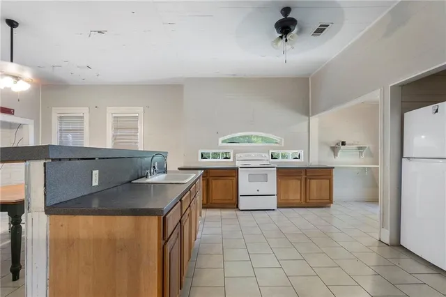 a kitchen with a stove a sink a refrigerator and window