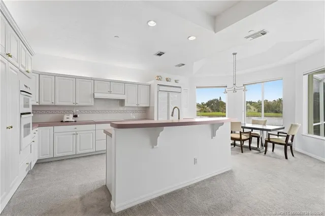 a kitchen with a sink window and chairs
