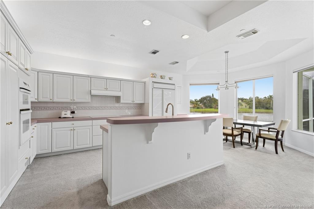 800 Southeast Waterside Way Stuart, FL 34997 - Photo 16 of 27 a kitchen with a sink window and chairs