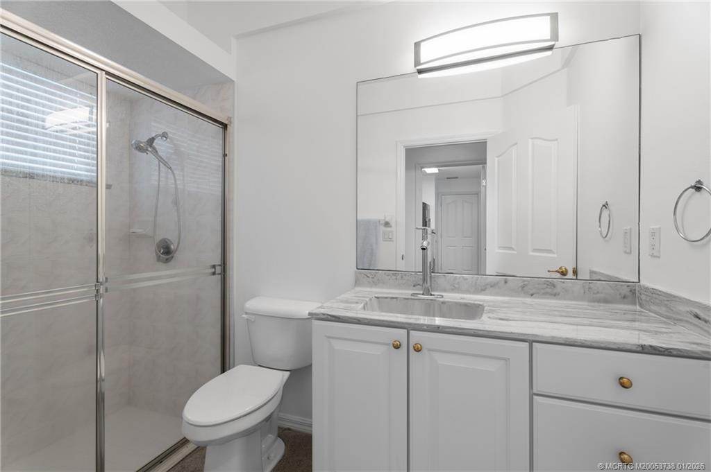 800 Southeast Waterside Way Stuart, FL 34997 - Photo 21 of 27 a bathroom with a granite countertop sink toilet and shower