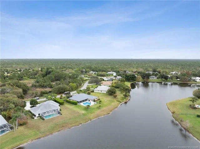 an aerial view of residential houses with outdoor space and lake view