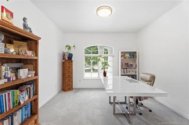 a view of a workspace with furniture and a book shelf
