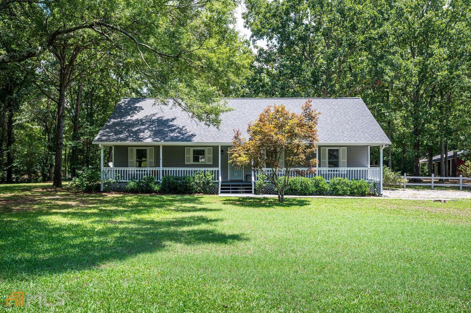 a front view of a house with a yard and trees
