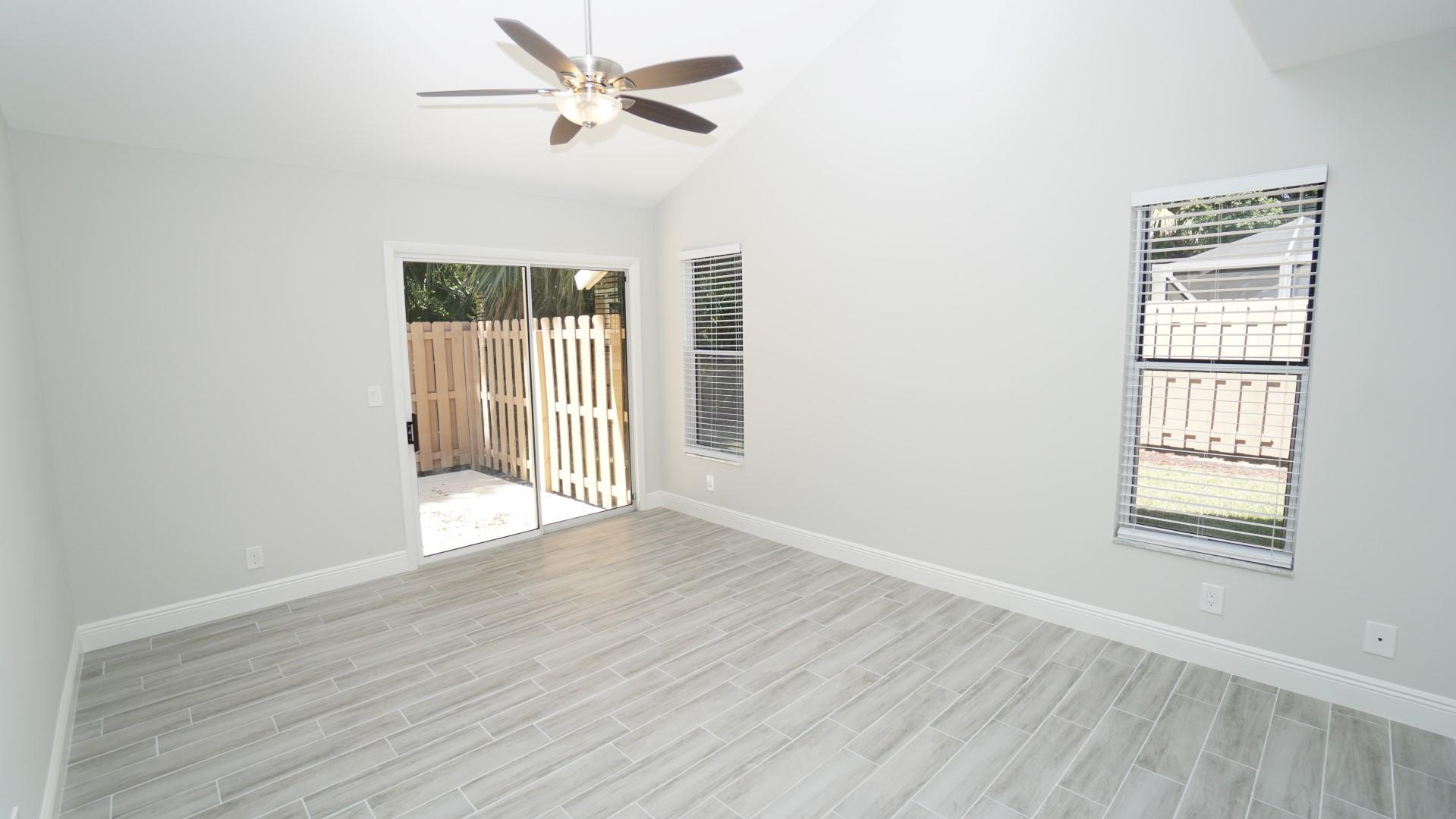 91 Maplecrest Circle Jupiter, FL 33458 - Photo 12 of 27 an empty room with wooden floor fan and windows