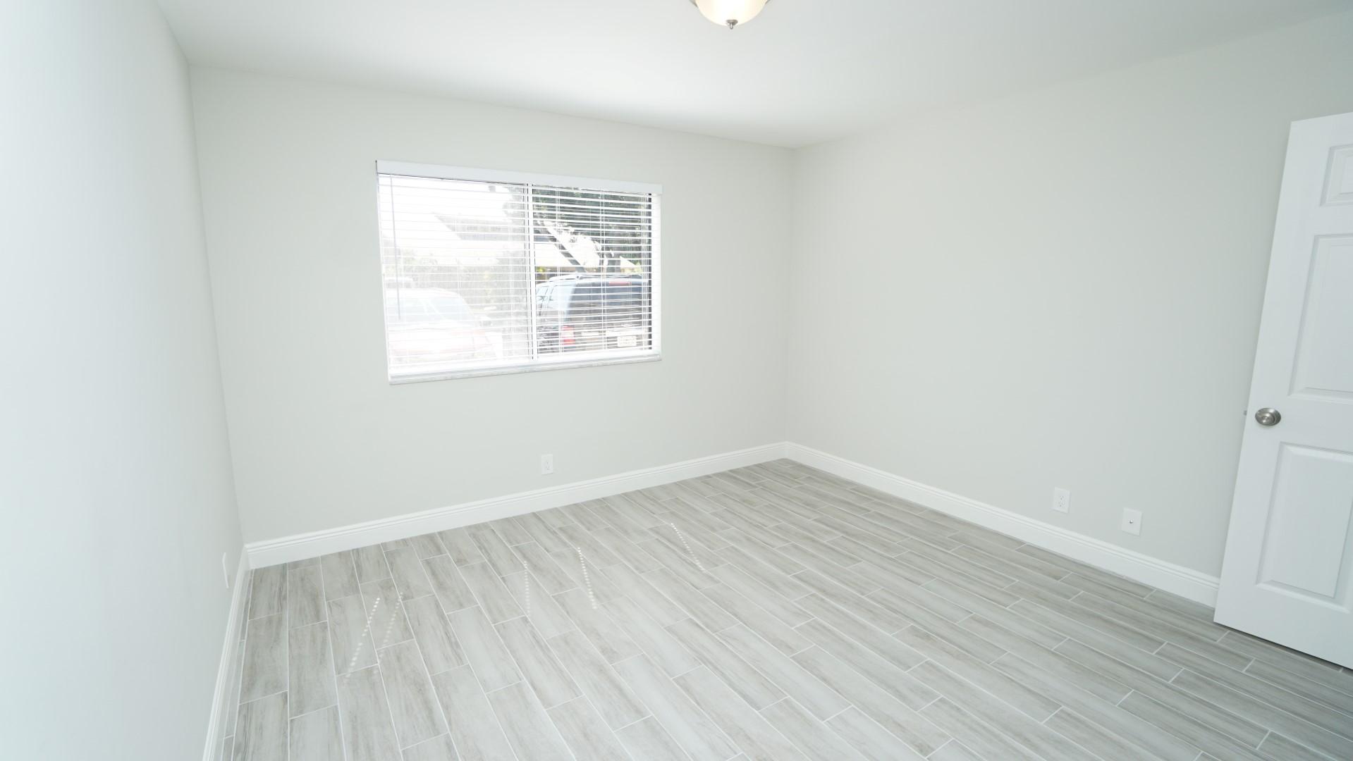 91 Maplecrest Circle Jupiter, FL 33458 - Photo 15 of 27 an empty room with wooden floor and windows
