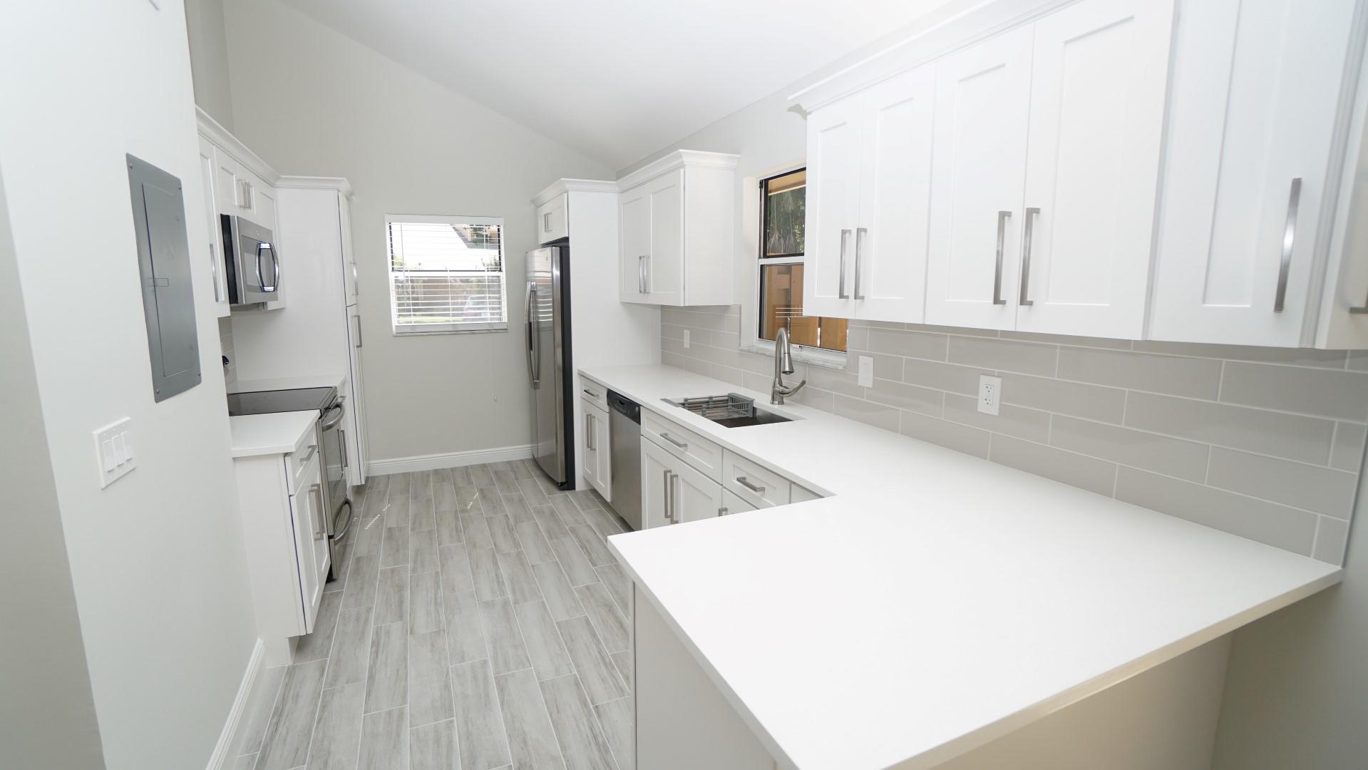91 Maplecrest Circle Jupiter, FL 33458 - Photo 5 of 27 a kitchen with cabinets and wooden floor