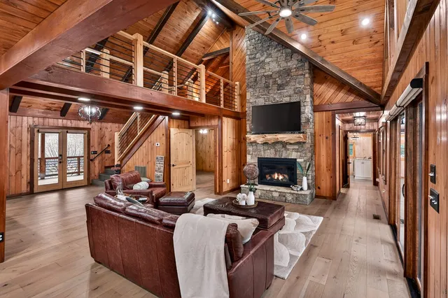 a living room with couches a fireplace with wooden floor and a fireplace