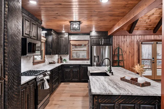 a kitchen with stainless steel appliances granite countertop a sink stove and cabinets