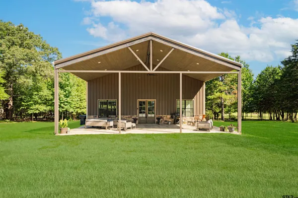 a patio with a table and chairs and a big yard