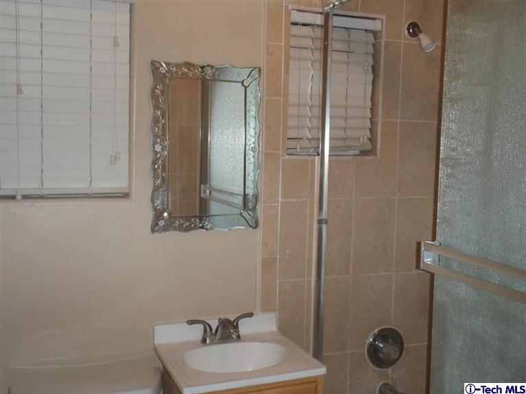 11533 Ranchito Street El Monte, CA 91732 - Photo 18 of 30 a bathroom with a sink mirror and shower