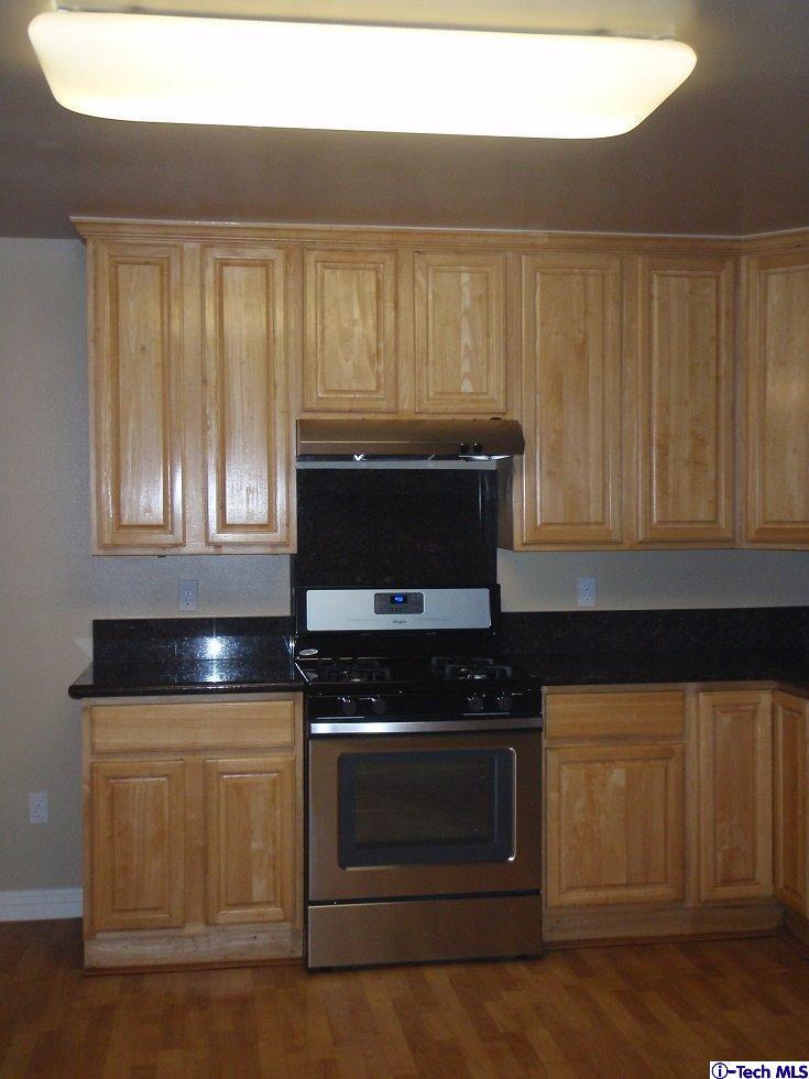 11533 Ranchito Street El Monte, CA 91732 - Photo 19 of 30 a kitchen with granite countertop a stove and a microwave