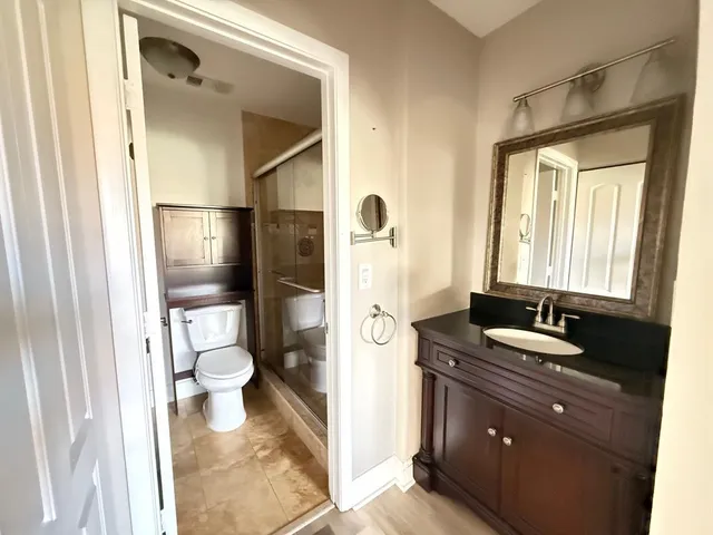 a bathroom with a granite countertop sink toilet and shower