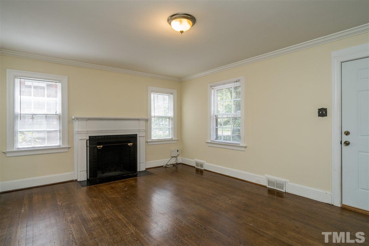 2254 The Circle Raleigh, NC 27608 - Photo 4 of 22 an empty room with wooden floor fireplace and windows