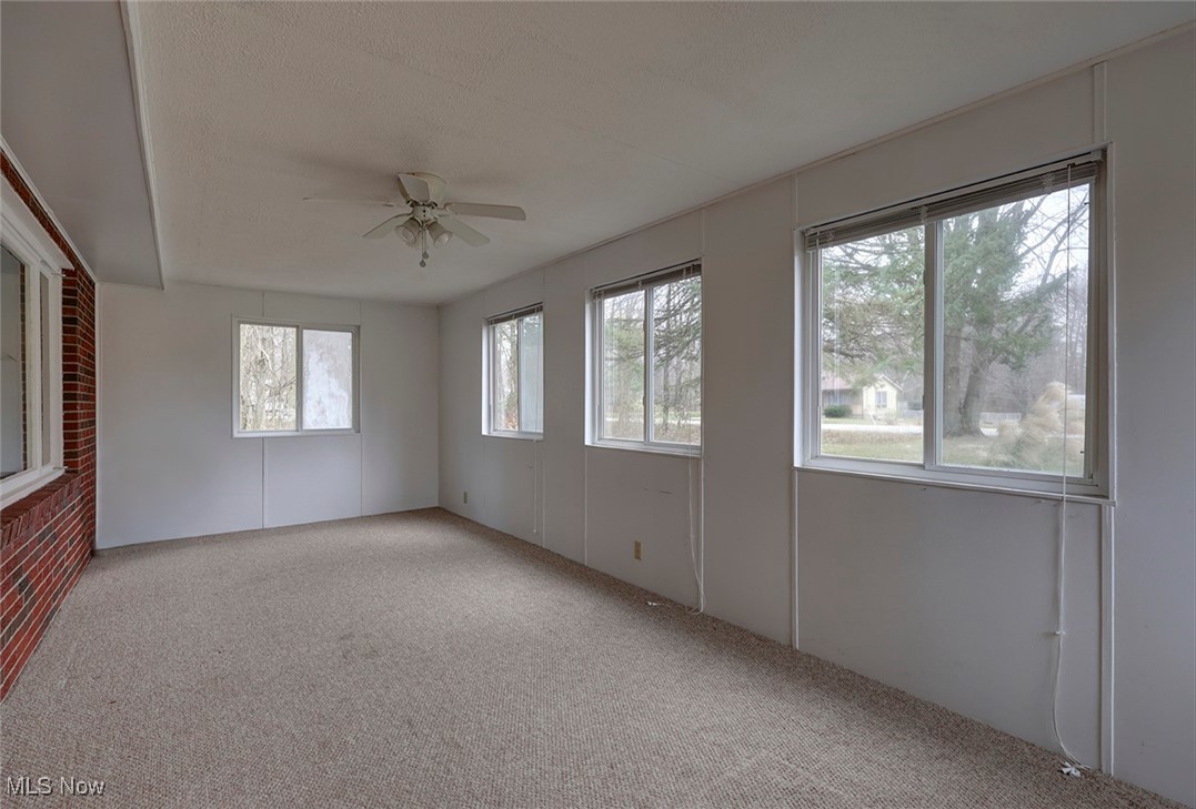 8104 Barnes Road Vermilion, OH 44089 - Photo 6 of 40 Unfurnished enclosed front porch with light carpet and ceiling fan